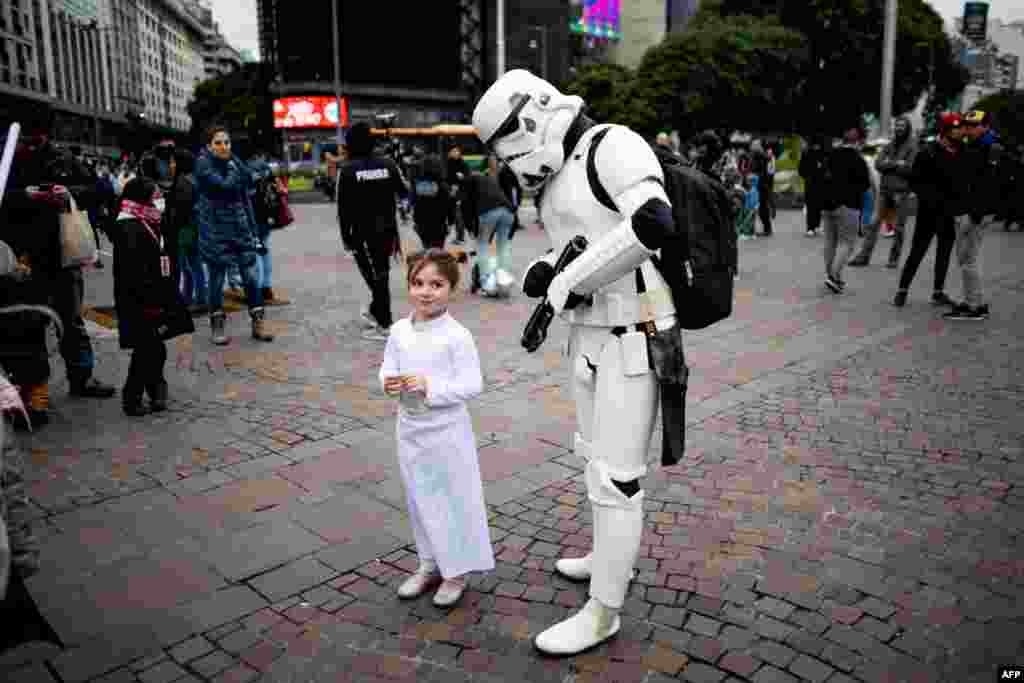 Fans of the Star Wars saga cosplaying as the characters Princess Leia (L) and a stormtrooper take part in the so-called "Meet From Another Galaxy" gathering in Buenos Aires, Brazil, June 2, 2024. 