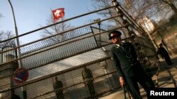 FILE - Iranian police stand guard outside Switzerland's embassy in Tehran, Feb. 9, 2007. 