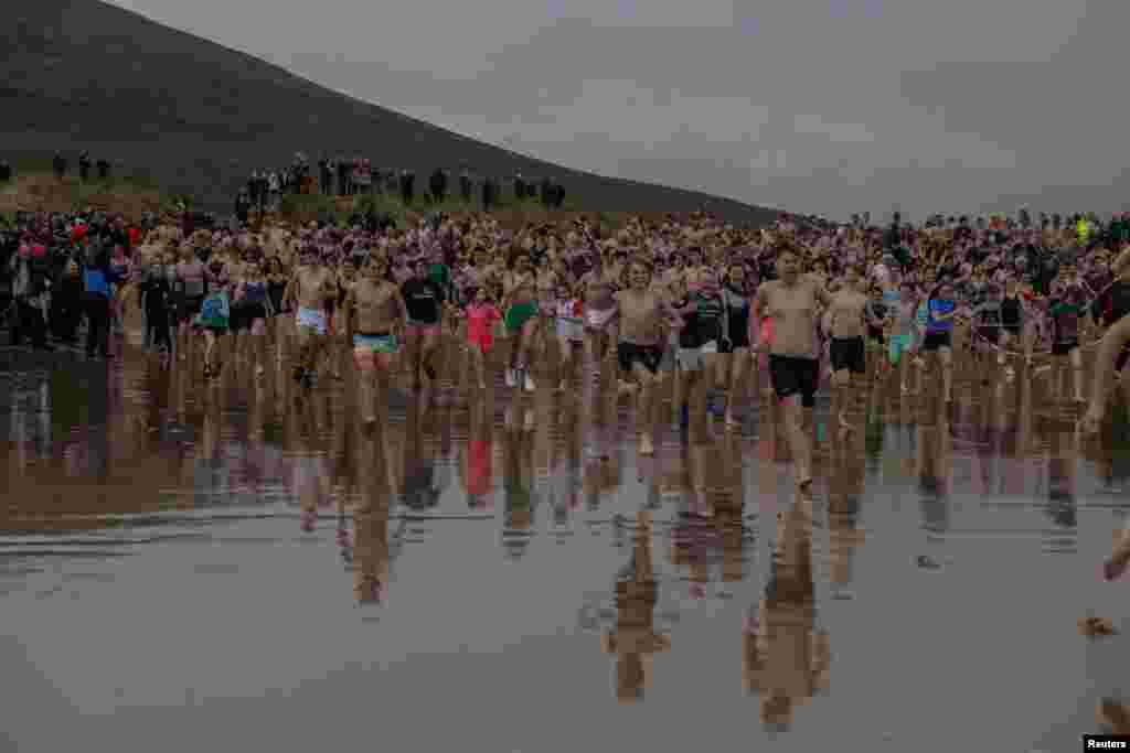 Swimmers make their way into the Atlantic Ocean as part of a New Year&#39;s Day charity swim at Dugort Silver Strand Beach on Achill Island, Ireland.