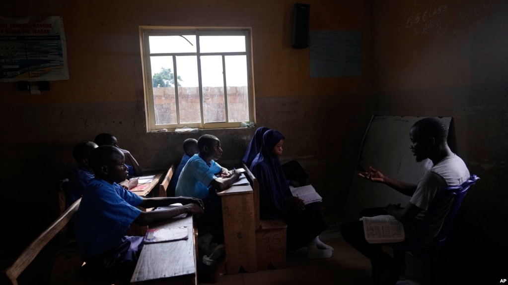 Students of Excellent Moral School attend a lesson in a window-lit classroom in Ibadan, Nigeria, Tuesday, May 28, 2024. (AP Photo/Sunday Alamba)