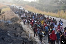 Migrants walk along the highway through Arriaga, Chiapas state, in southern Mexico, on Jan. 8, 2024, during their journey north toward the U.S. border.