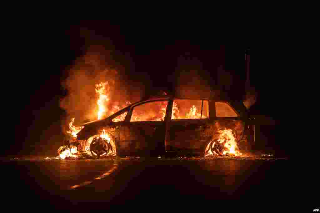 A car is on fire on Riviere Salee&#39;s main road in Noumea, in the French Pacific territory of New Caledonia. A fresh surge of unrest hit the territory, with several buildings set on fire overnight, including a police station and a town hall, authorities said.