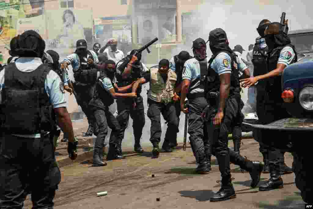 A bodyguard of former President of Madagascar and presidential candidate Marc Ravalomanana is arrested by the Gendarmerie in Antananarivo. (Photo by RIJASOLO / AFP)