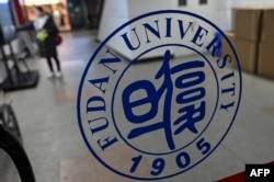 FILE - A Fudan University sign is seen on the campus in Shanghai, Dec. 18, 2019.