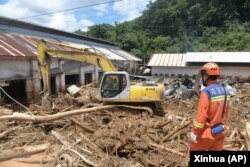 Dalam foto yang dirilis oleh Kantor Berita Xinhua ini, tim penyelamat membersihkan puing-puing di daerah yang terkena dampak banjir di Sishui, Kabupaten Pingyuan, Kota Meizhou, Provinsi Guangdong, China selatan, 20 Juni 2024. (Lu Hanxin/Xinhua via AP)