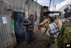 Police beat a protester who had hidden in a shack, after police threw a tear gas grenade inside to force him out, in the Kibera slum of Nairobi, Kenya, March 20, 2023.