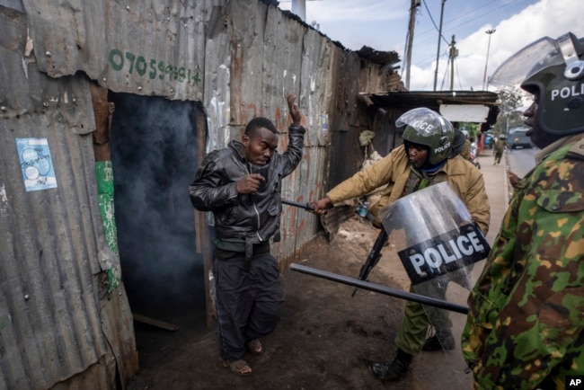 Police beat a protester who had hidden in a shack, after police threw a tear gas grenade inside to force him out, in the Kibera slum of Nairobi, Kenya, March 20, 2023.