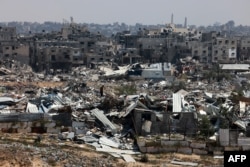 Čovek stoji usred ruševina obekata unštenih u izraelskim bombardovanjima, u Kan Junisu, 7. aprila 2024.