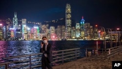 FILE - A man talks on his phone in front of the skyline in Hong Kong, Oct. 19, 2022.