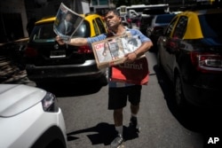 Seorang pedagang kaki lima menjual koran yang menampilkan pelantikan Presiden Argentina Javier Milei sehari sebelumnya di Buenos Aires, Argentina, Senin, 11 Desember 2023. (Foto: AP)