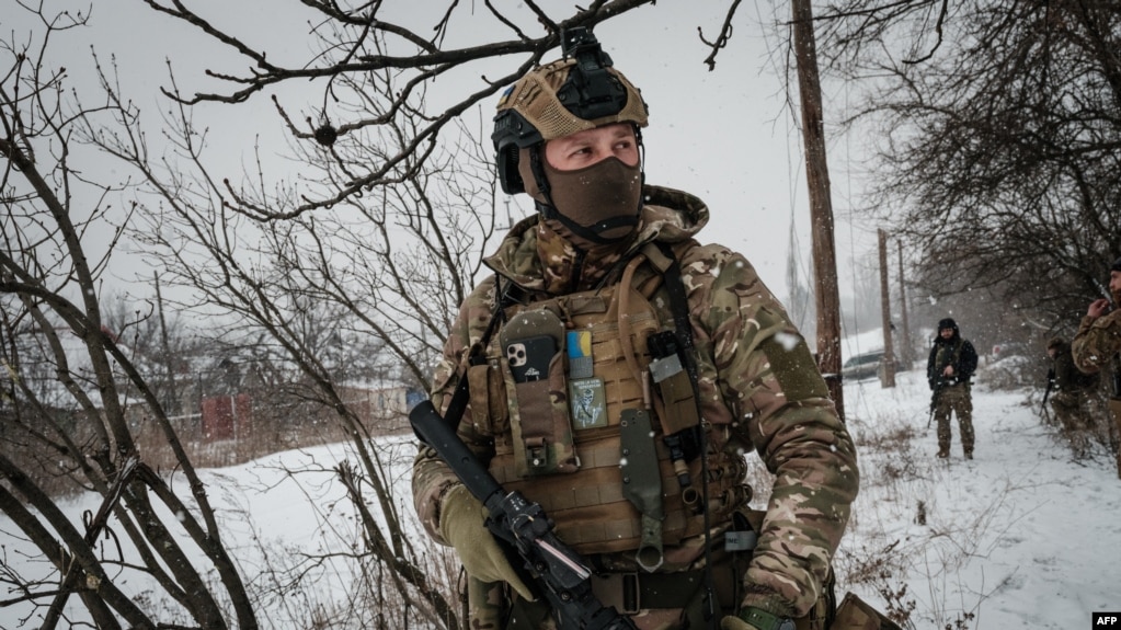 A serviceman, call sign 'Virus,' of the Ukrainian Armed Forces Vedmak ('Witcher') unit patrols on the front line near Bakhmut on Feb. 18, 2023.