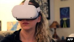 ILUSTRASI - Amy Erdt duduk di ruang tamunya di Portland, Oregon, menjelajahi kota-kota asing secara virtual dengan mengenakan headset Oculus miliknya, 19 Maret 2021. (Deborah BLOOM / AFP)
