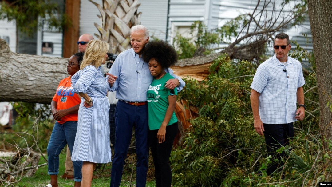 US President Joe Biden and first lady Jill Biden speak with a woman during their tour of Hurricane Idalia storm destruction, Live Oak, Florida, Sept. 2, 2023. 