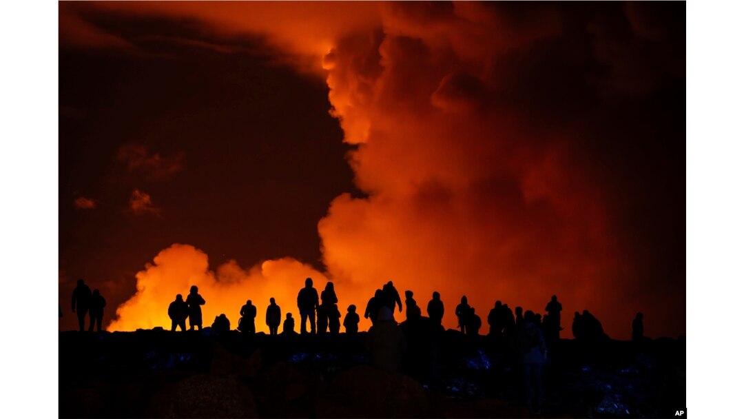 Spectators watch plumes of smoke from volcanic activity between Hagafell and Stori-Skogfell, Iceland, March 16, 2024.
