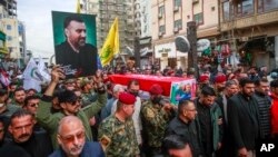 People walk in a funeral procession for Iranian senior commander General Razi Mousavi, in Najaf, Iraq, Dec. 27, 2023, ahead of the transfer of his body to Iran for burial. Mousavi was killed in an Israeli airstrike Monday near Damascus, Syria.