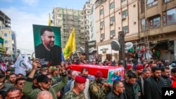 2023年12月27日，在伊拉克纳杰夫，人们行走在伊朗高级指挥官拉齐·穆萨维将军的葬礼队伍中。他的遗体被转移到伊朗安葬。（美联社照片）
