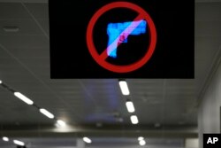 A television displays a "no guns" sign at the Transportation Security Administration security area at the Hartsfield-Jackson Atlanta International Airport on Wednesday, Jan. 25, 2023, in Atlanta. (AP Photo/Brynn Anderson)