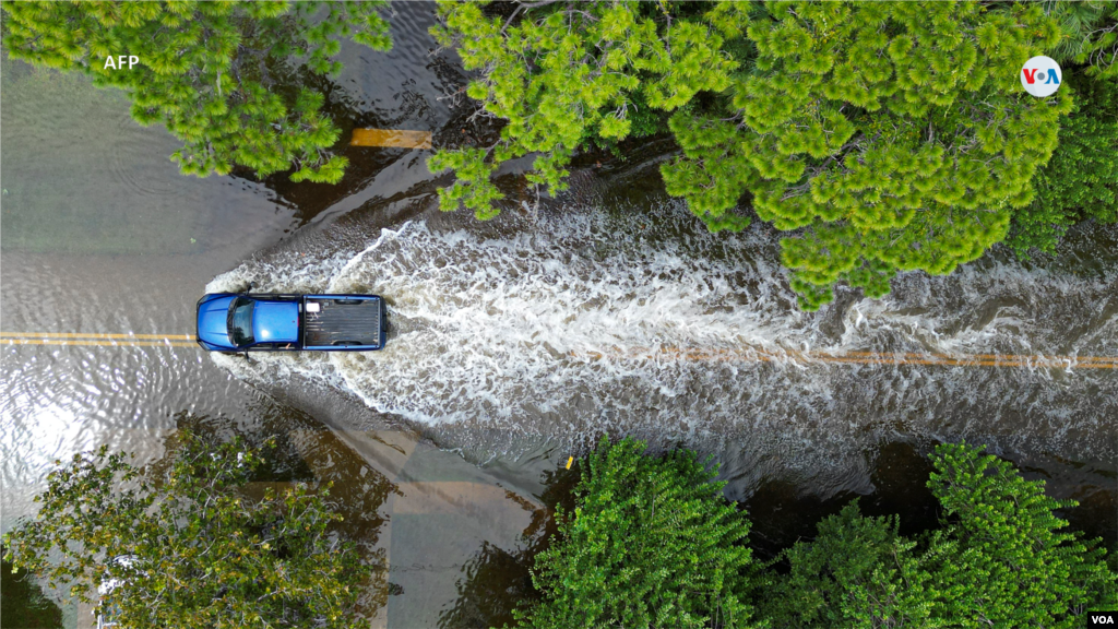 Una vista aérea muestra un vehículo avanzando por una calle inundada en New Port Richey, Florida, el 30 de agosto de 2023, después de que el huracán Idalia tocara tierra.