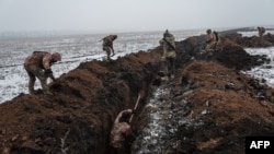 FILE: In this photo taken on Feb. 01, 2023 Ukrainian servicemen make a trench near Bakhmut, where Russian forces are focused on taking that town.