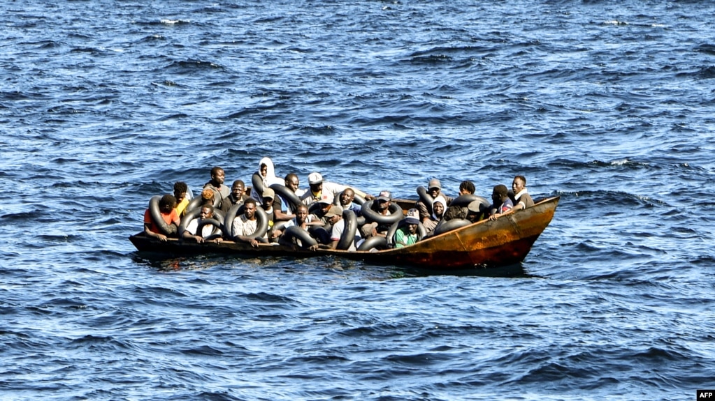 Migrants of African origin are crammed on board a small boat as Tunisian coast guards prepare to transfer them onto their vessel, at sea between Tunisia and Italy, Aug. 10, 2023.