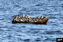 FILE - Migrants of African origin are crammed on board a small boat as the Tunisian coast guard prepares to transfer them onto its vessel, at sea between Tunisia and Italy, on Aug. 10, 2023. Most of the 261,000 migrants who entered Europe illegally in 2023 came to Italy.