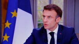 Presiden Prancis Emmanuel Macron terlihat di layar televisi selama wawancara dari Istana Elysee, di Paris, 22 Maret 2023.