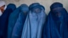 FILE - Afghan women wait to receive food distributed by a humanitarian aid group in Kabul, Afghanistan, May 23, 2023. Taliban leaders in Afghanistan have ordered fresh limitations on women, including mandating them to keep their faces and bodies covered at all times.