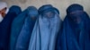 FILE - Afghan women wait to receive food rations distributed by a humanitarian aid group, in Kabul, Afghanistan, May 23, 2023. 