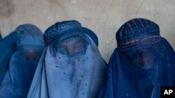 কাবুলে একটি মানবিক সহায়তা গোষ্ঠীর বিতরণ করা খাদ্য রেশন পাওয়ার জন্য আফগান নারীরা অপেক্ষা করছেন। ২৩ মে, ২০২৩। ফাইল ছবি। 