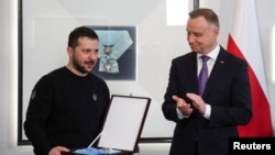 Poland's President Andrzej Duda honors Ukrainian President Volodymyr Zelenskiy with The Order of the White Eagle at the Presidential Palace in Warsaw, Apr. 5, 2023.