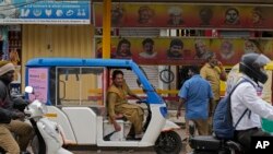 Preethi, perempuan transgender berusia 38 tahun, memarkir becak listriknya di samping halte bus untuk mencari penumpang di Bengaluru, India, Rabu, 12 Juli 2023. (AP/Aijaz Rahi)