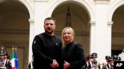 Italian Premier Giorgia Meloni, right, and Ukrainian President Volodymyr Zelenskyy shake hands before a meeting at Chigi Palace, Rome, May 13, 2023. Zelenskyy will meet the pope later.