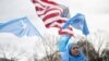 FILE - People hold up flags and signs during a protest in Washington on Feb. 5, 2023, marking the 26th anniversary of the 1997 Ghulja massacre in Ghulja City, in the Xinjiang province of China. More than 100 Uyghur died in the incident.