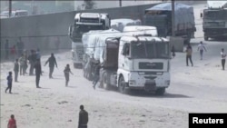 Orang-orang mengejar konvoi truk bantuan yang melaju ke Gaza dari penyeberangan Rafah, 9 April 2024, dalam tangkapan layar yang diambil dari video. (REUTERS TV/via REUTERS)