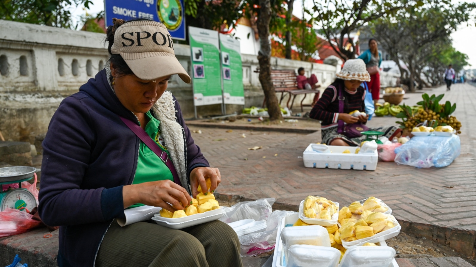 FILE - Women prepare jackfruit for sale along a street in Luang Prabang, Laos, Jan. 31, 2024.