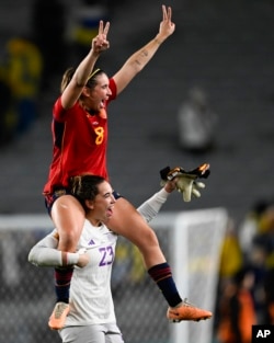 Spain's goalkeeper Cata Coll carries teammate Mariona Caldentey as they celebrate a a Women's World Cup semifinal victory over Sweden at Eden Park in Auckland, New Zealand, Aug. 15, 2023.