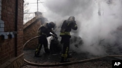 Rescue workers put out the fire of a car which was shelled by Russian forces at the residential neighbourhood in Kostiantynivka, Ukraine, Friday, March 10, 2023.