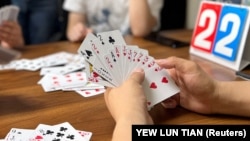 FILE - Finance professionals learn how to play guandan, a poker-like card game, during a training session in Beijing, China, August 6, 2023. (REUTERS/Yew Lun Tian)