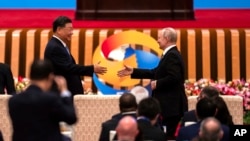 Chinese President Xi Jinping, left, and Russian President Vladimir Putin shake hands during the Belt and Road Forum at the Great Hall of the People in Beijing, Oct. 18, 2023. 
