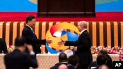 Presiden China Xi Jinping (kiri) dan Presiden Rusia Vladimir Putin berjabat tangan selama Forum Belt and Road di Aula Besar Rakyat di Beijing, 18 Oktober 2023.