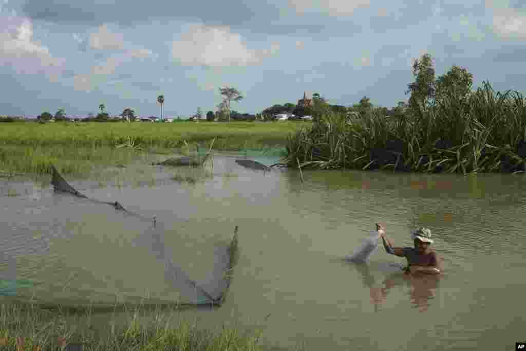 A man fishes in the flood water from recent rain at Tomnup Trent outside Phnom Penh Cambodia