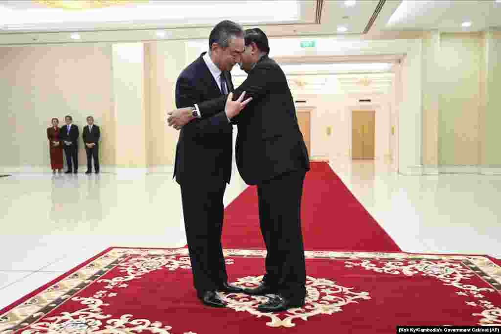 លោក​នាយករដ្ឋមន្ត្រី​ ហ៊ុន សែន (ស្តាំ) ឱប​ជាមួយ​រដ្ឋមន្ត្រី​ការ​បរទេស​ចិន​លោក Wang Yi (វ៉ាង យី) នៅ​វិមាន​សន្តិភាព ក្នុង​រាជធានី​ភ្នំពេញ កាល​ពី​ថ្ងៃ​អាទិត្យ ទី​១៣ ខែ​សីហា ឆ្នាំ​២០២៣។ (Kok Ky/Cambodia's Government Cabinet via AP)