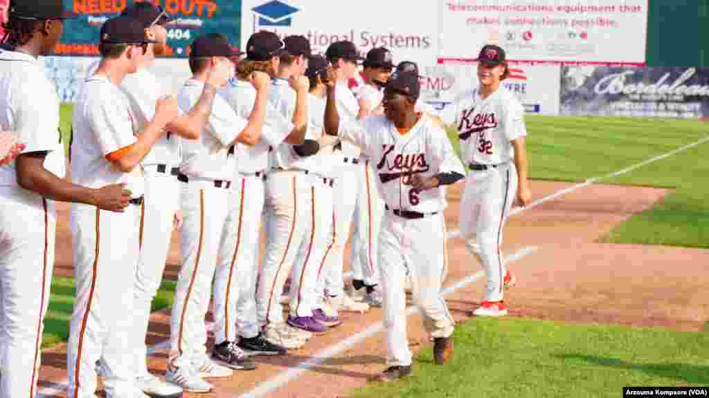 Dennis Kasumba fait un high-five à ses coéquipiers ses coéquipiers avec les Frederick Keys de baseball de Frederick Keys au Stade Harry Grove à Frederick, Maryland le 3 juin 2023. (VOA/Arzouma Kompaore)