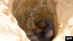 FILE—A man digs in a hole as he searches for gold in Kafa-Koira, south of Niamey, Niger, April 25, 2017. Several gold mines in the country's north were shuttered after animal died apparently from drinking wastewater which, local herders say, contained harmful products.