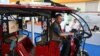 FILE - An exhibitor sits inside an E-rickshaw on display during the Hyderabad E-Motor Show at Hitex Exhibition Centre in Hyderabad, Feb. 8, 2023. 