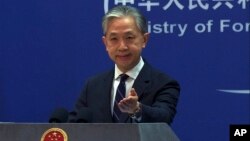 FILE - In this image from video, Chinese Foreign Ministry spokesperson Wang Wenbin gestures as he speaks during a media briefing at the ministry in Beijing, Feb. 13, 2023.