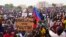 FILE - Aksi unjuk rasa pendukung pemimpin kudeta Jenderal Abdourahmane Tchiani di Niamey, Niger, Minggu, 30 Juli 2023. Poster berbunyi: Hancurkan Prancis, hidup Putin." (AP/Sam Mednick, File)
