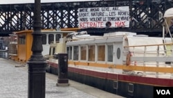 A poster against raising the retirement age is seen hung on a bridge in Paris. (Lisa Bryant/VOA)