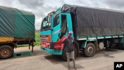 Stranded trucks with goods sit the border between Nigeria and Niger in Jibia, Nigeria, Aug. 7, 2023. The West Africa regional bloc's decision to shut borders with Niger in sanctioning the country's coup plotters is affecting businesses and locals.