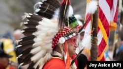 Blas Preciado, the vice commander of the Kiowa Blackleggings Warrior Society, takes part in the dedication of the National Native American Veterans Memorial on Friday, Nov. 11, 2022 in Washington. 